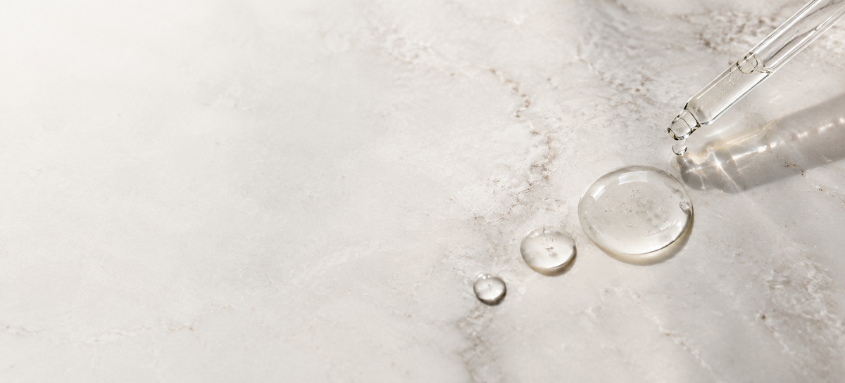 Three serum droplets beside a glass pipette.