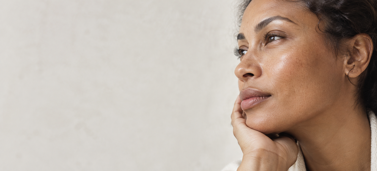Brown skin with natural uneven pigmentation in soft daylight.